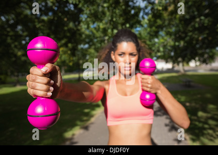 Fit junge Frau, die das Training mit Hanteln im park Stockfoto