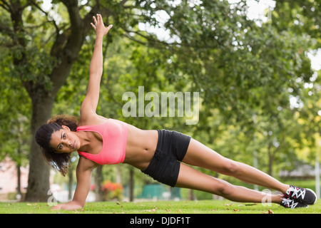 Getönten junge Frau tun stretching-Übung im park Stockfoto