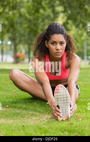 Porträt einer schönen sportlichen Frau dehnen ihr Bein im park Stockfoto