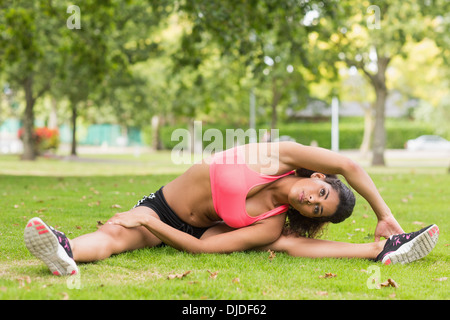 Straff und flexible Frau tun stretching-Übung im park Stockfoto