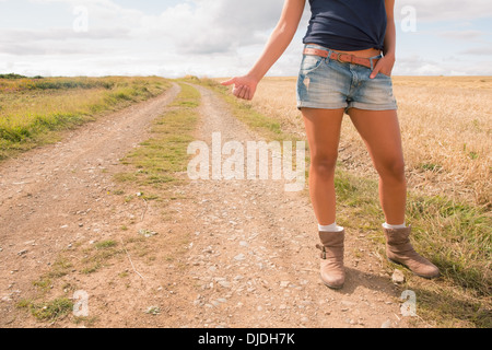 Coole Frau Trampen auf Feldweg Landschaft Stockfoto