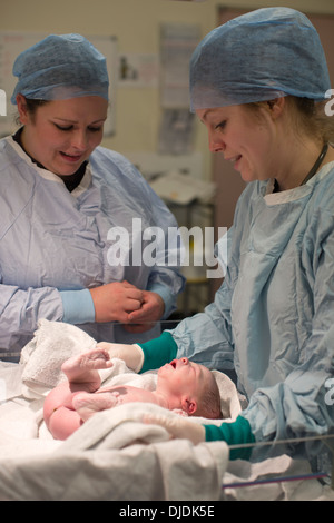 Neugeborenes Baby Boy geprüft von Krankenschwestern im Krankenhaus Mutterschaft Theater auf der Arbeit-Station im Krankenhaus, Kingston nach Themse, UK Stockfoto