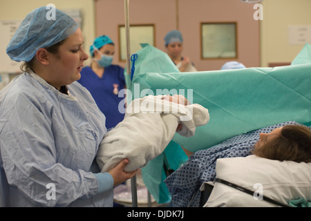 Neugeborenes Baby Boy geprüft von Krankenschwestern im Krankenhaus Mutterschaft Theater auf der Arbeit-Station im Krankenhaus, Kingston nach Themse, UK Stockfoto