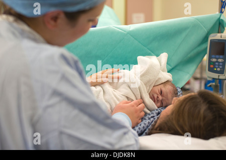 Neugeborenes Baby Boy geprüft von Krankenschwestern im Krankenhaus Mutterschaft Theater auf der Arbeit-Station im Krankenhaus, Kingston nach Themse, UK Stockfoto