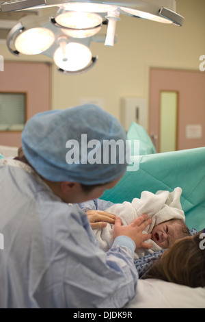 Neugeborenes Baby Boy geprüft von Krankenschwestern im Krankenhaus Mutterschaft Theater auf der Arbeit-Station im Krankenhaus, Kingston nach Themse, UK Stockfoto