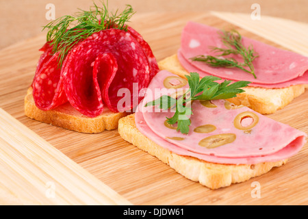 Sandwiches mit Salami und Mortadella auf Holzbrett. Stockfoto