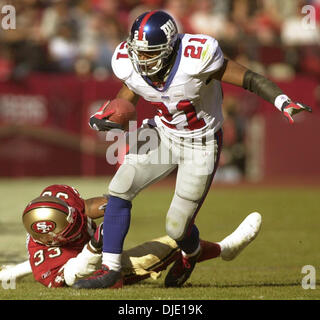 5. Januar 2003; San Francisco, CA, USA; New York Giants Runningback Tiki Barber vermeidet ein Tackling von 49ers Tony Parrish im 1. Quartal ihre NFC-Joker-Spiel im Candlestick Park in San Francisco Sonntag Januar 5,2003. Stockfoto