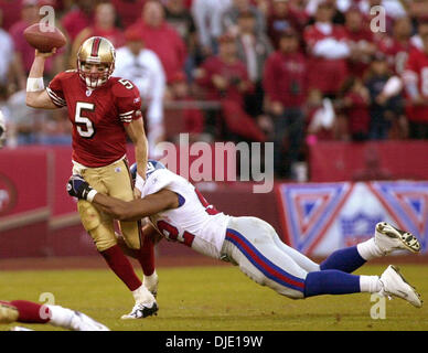 5. Januar 2003; San Francisco, CA, USA; 49ers Quarterback Jeff Garcia bekommt Druck von New York Riesen Michael Strahan im 4. Quartal ihre NFC Wildcard-Spiel im Candlestick Park in San Francisco Kalifornien, Sonntag Januar 5,2003. Stockfoto