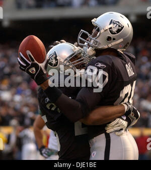 12. Januar 2003; Oakland, Kalifornien, USA; Oakland Raiders Runningback Charlie Garner, Umarmungen links, Jerry Rice in der Endzone nach Reis ein Touchdown im 4. Quartal ihre AFC divisional Playoff-Spiel auf Sonntag, 12. Januar 2003 an Network Associates Coliseum in Oakland, Kalifornien erzielt Die Raiders schlagen die Jets 30-10. Stockfoto