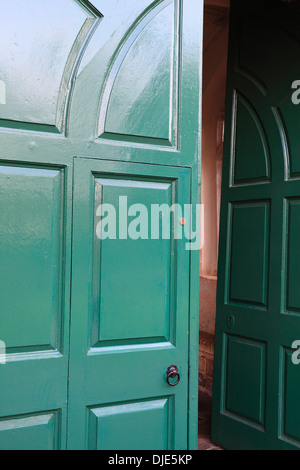 Grüne Tür angelehnt. Eingang zur Abtei Wymondham. Stockfoto