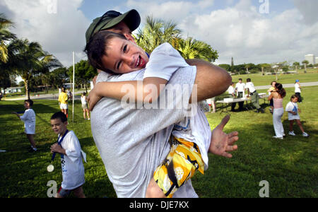 16. Mai 2004; Palm Beach, FL, USA; SEAN HEFFERNAN, 6, von Miami, bekommt eine Umarmung von Vater DAVID nach Überqueren der Ziellinie in der zweiten jährlichen FitKids-Triathlon bei Gaines Park Sonntagmorgen. FitKids-Triathlon, gesponsert von der Stadt von West Palm Beach Parks and Recreation Department, zog etwa 175 Kinder Alter 4-14 aus ganz Süd-Florida zu schwimmen, Radfahren und laufen in 3 Altersgruppen. Stockfoto