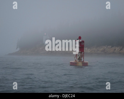 Eine rote und weiße Boje und der Bass Harbor Leuchtturm im Nebel entlang der Küste von Maine USA Stockfoto