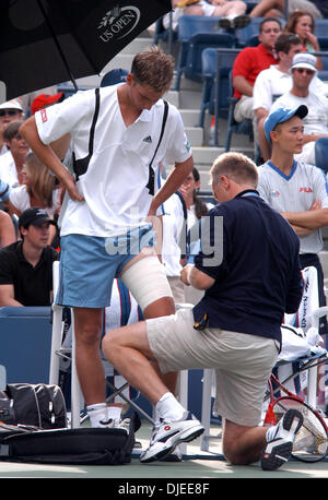 Sep 02, 2004; Flushing Meadows, New York, USA; FLORIAN MAYER von Deutschland bekommt sein Bein mit Klebeband von Trainer in seiner 2. Vorrundenspiel gegen Andre Agassi der USA bei den US Open in Flushing Meadows, NY. Mayer hatte in den Ruhestand wegen Verletzungen während des vierten Satzes mit Agassi 7-5, 6-2, 2-6, und dann 1: 0 im vierten Satz führt. Stockfoto