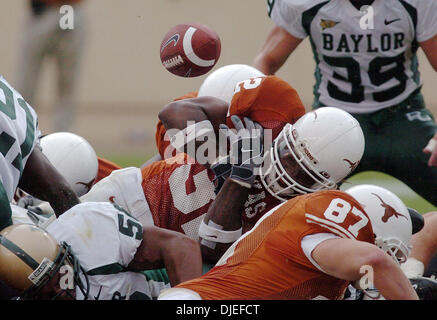 2. Oktober 2004; AUSTIN, TEXAS, USA; NCAA College-Football: Die Fußball erscheint Lose von Longhorns Cedric Benson ebenso, wie er eines seiner zwei Touchdowns in der ersten Hälfte gegen der Baylor Bears Darrell Royal Stadion am Samstag, den 2. Oktober punktet. Stockfoto