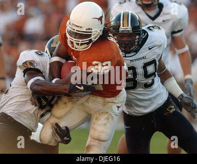 16. Oktober 2004; Austin, TX, USA; NCAA College Football - Texas Vs Missouri - Cedric Benson durchbricht die Bekämpfung des Missouris Marcus King (36) und Brian Smith (39) für einen Touchdown in der zweiten Hälfte Samstag, 16. Oktober 2004 im Memorial Stadium. Stockfoto