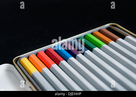 Buntstifte in Zinn auf schwarzem Hintergrund Stockfoto