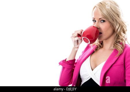 Selbstbewussten jungen Professionellen Geschäftsfrau, Entspannen mit einem roten Becher Kaffee, allein, in Ihrem Büro, Wiederherstellung nach einem harten Arbeitstag Stockfoto