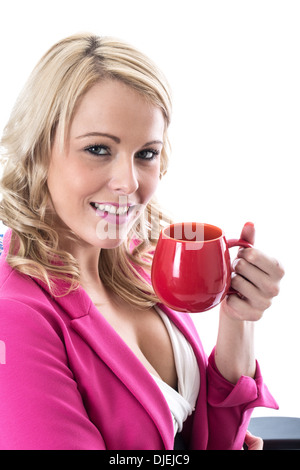 Selbstbewussten jungen Professionellen Geschäftsfrau, Entspannen mit einem roten Becher Kaffee, Allein, sitzt in ihrem Büro, Wiederherstellung nach einem harten Arbeitstag Stockfoto