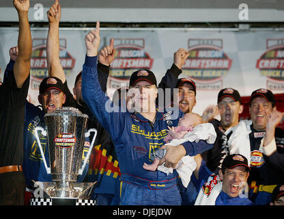 19. November 2004; Homestead, FL, USA; BOBBY HAMILTON, feiert Sieger der Nascar Craftsman Truck Series.Championship mit Teamkollegen während seiner Enkelin Haylie halten. Stockfoto