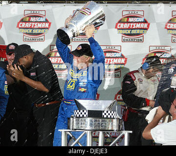 19. November 2004; Homestead, FL, USA; BOBBY HAMILTON, hisst Gewinner der Nascar Craftsman Truck Series Championship Trophy während der Preisverleihung auf dem richtigen Weg auf dem Homestead-Miami Speedway Freitagnachmittag. Stockfoto