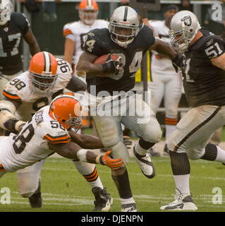 Sep 23, 2007 - OAKLAND, CA, USA - Oakland Raiders Runningback LAMONT JORDAN #34 durchbricht die Bekämpfung der Cleveland Browns Linebacker D'QWELL JACKSON #58 mit aus Oakland Raiders Center CHRIS MORRIS #51 während ihr Spiel im McAfee Coliseum helfen. (Kredit-Bild: © Al Golub/ZUMApress.com) Stockfoto