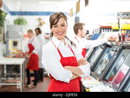 Zuversichtlich weibliche Metzger stehend Arme gekreuzt Stockfoto