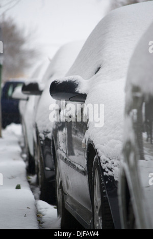 Reihe von parkenden Autos nach Schneefall auf Straße Stockfoto