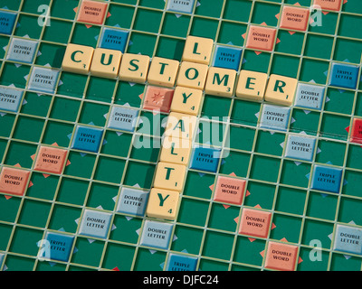 Die Phrase "Kundenbindung", geschrieben mit Scrabble Fliesen auf einem Scrabble-Brett. Stockfoto