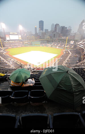 4. Juni 2010 - Pittsburgh, PA, USA - 4. Juni 2010: Baseball-Fans sitzen im Regen unter dem Schutz der Sonnenschirme Blick auf einer Plane bedeckt Feld Beginn der Piraten gegen die Giants im PNC Park in Pittsburgh, PA. warten... Für das zweite Spiel in Folge hatten die Piraten eine längeren regen Verzögerung mit den ersten Pitch auf 22:00 3 Stunden nach der ursprünglichen sta Stockfoto