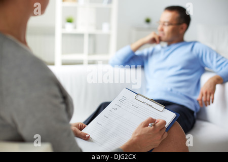 Weibliche Psychologe Notizen während psychologische Therapie-Sitzung Stockfoto