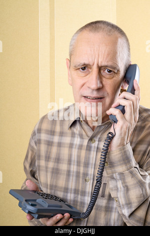 Aufgeregt Mann mit schlechten Nachrichten und eine Telefon in der hand halten Stockfoto