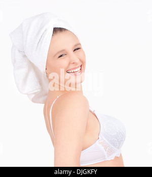 Schöne junge Frau mit Handtuch auf ihrem Kopf lächelnd - Isolated on White Stockfoto