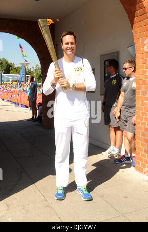 Die Olympische Flamme erfolgt durch Michael Vaughan durch Hillingdon im Rahmen der Olympic Torch Relay London, England - 24.07.12 Stockfoto