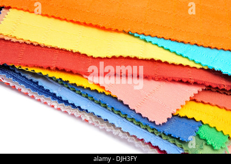 einige Stücke aus Stoff mit verschiedenen Farben und Mustern auf weißem Hintergrund Stockfoto
