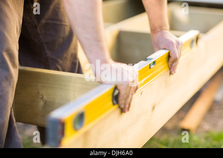 Zimmermanns Hände Überprüfung Ebene aus Holz am Standort Stockfoto