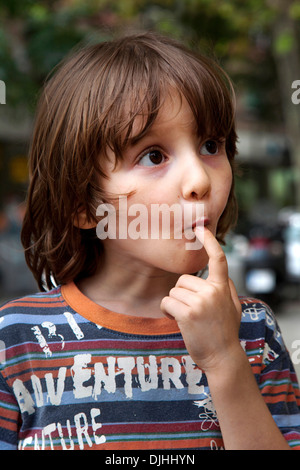 Fünf Jahre alter Junge er seinen Finger in den Mund. Stockfoto