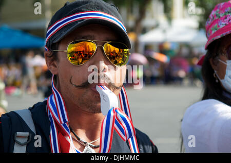 Bangkok, Thailand. 28. November 2013. ein Thai-Demonstrator & Democrat Party Unterstützer bläst seine Pfeife in einem Aufruf für einen Wechsel in der Regierung während einer Anti-Regierungs-Rallye am Demokratie-Denkmal in Bangkok. Democracy Monument spiegelt sich in seine Sonnenbrille. Bildnachweis: Kraig Lieb / Alamy Live News Stockfoto