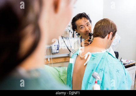 Arzt mit Otoskop Ohr des Patienten im Krankenhaus untersuchen Stockfoto