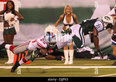 16. August 2010 - Rutherford, New Jersey, Vereinigte Staaten von Amerika - 16. August 2010: New York Jets Runningback LADAINIAN TOMLINSON (#21) von New York Giants Cornerback BRUCE JOHNSON (#25) in Angriff genommen. New York Jets Hauptrolle die New York Giants 13-10 bei der Hälfte in Vorsaison während des Spiels spielen spielte im New Meadowlands Stadium in Rutherford, New Jersey. Obligatorische Credit: Anthony Grupp Stockfoto