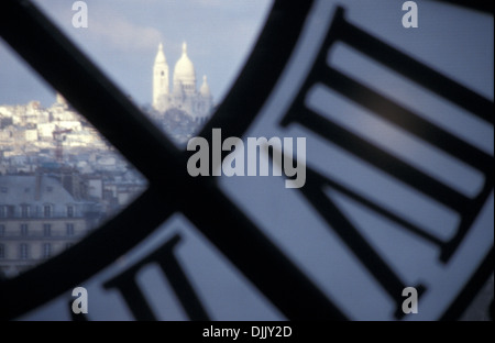 Die Basilika des Heiligen Herzen von Paris, umgangsprachlich Sacré-Cœur, durch die Uhr des Musée d ' Orsay, Paris Stockfoto