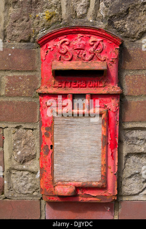 schäbige stillgelegten George V Lampe Briefkasten set in eine Wand, Arford, Hindhead, Surrey Stockfoto