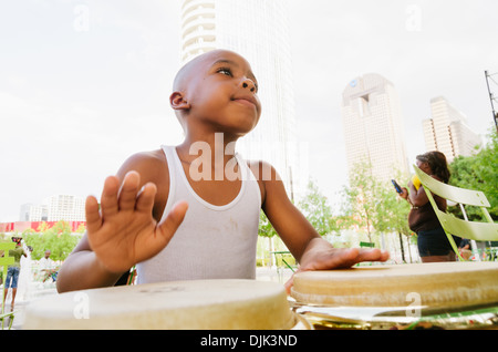 Afroamerikanischen Kind spielt Bongos in Klyde Park, Downtown Dallas. Stockfoto