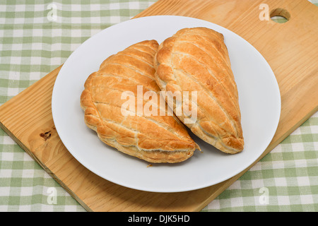 zwei Cornish Pasties auf einer Platte in einem Café-Ambiente Stockfoto