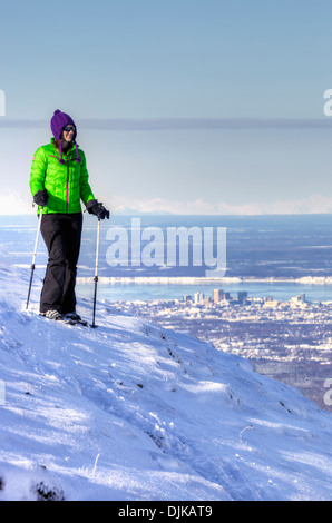 Frau Schneeschuhwanderer unter In der Ansicht von Blueberry Hill im Bereich Glen Alpen des Chugach State Park mit Blick auf Anchorage Stockfoto