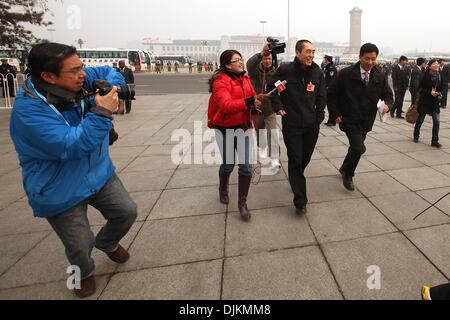 Peking, China. 3. März 2010. Berühmte chinesische Regisseur Zhang Yimou (C), auch einen chinesischen Delegierten, läuft aus der Presse, wie er auf dem Tiananmen-Platz vor der Eröffnungssitzung der chinesischen politischen Beratenden Konferenz (CPPCC) in der großen Halle des Volkes in Peking 3. März 2010 ankommt. Die chinesische Führung ist Gesetzgebung forciert, das Wirtschaftswachstum und die Verbesserung des Lebensstandards, vor allem bei Wanderarbeiter des Landes fördert. Stephen Shaver/ZUMAPRESS.com/Alamy © Live-Nachrichten Stockfoto