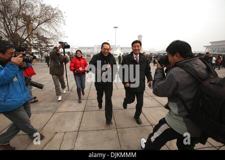 Peking, China. 3. März 2010. Berühmte chinesische Regisseur Zhang Yimou (C), auch einen chinesischen Delegierten, läuft aus der Presse, wie er auf dem Tiananmen-Platz vor der Eröffnungssitzung der chinesischen politischen Beratenden Konferenz (CPPCC) in der großen Halle des Volkes in Peking 3. März 2010 ankommt. Die chinesische Führung ist Gesetzgebung forciert, das Wirtschaftswachstum und die Verbesserung des Lebensstandards, vor allem bei Wanderarbeiter des Landes fördert. Stephen Shaver/ZUMAPRESS.com/Alamy © Live-Nachrichten Stockfoto