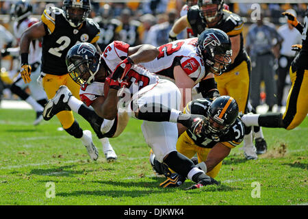 12. September 2010 - übernehmen Pittsburgh, PENNSYLVANNIA, Vereinigte Staaten von Amerika - Atlanta Falcons Runningback MICHAEL TURNER (33) schafft es zu bleiben an den Füßen nach oben von Pittsburgh Steelers innen Linebacker JAMES FARRIOR (51) ausgelöst wird im dritten Quartal als die Steelers die Falcons im Heinz Field in Pittsburgh, PA.... Steelers in der Overtime gewinnen über die Falken mit einem Score von 15 Stockfoto