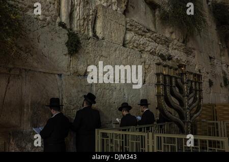 Orthodoxe Juden beten zu Chanukka hinter einer großen Hannukiya an der Klagemauer in der Altstadt von Jerusalem, am 28. November 2013 zu markieren. Chanukka, auch bekannt als das Festival of Lights und fest von Hingabe, ist eine achttägige jüdischer Feiertag zum Gedenken an die erneute Weihung des heiligen Tempels (der zweite Tempel) in Jerusalem zur Zeit der Makkabäer Revolte gegen Seleucid Reich des 2. Jh. v. Chr. Chanukka für acht Tage und Nächte, beobachtet ist ab dem 25. Tag von Kislev nach dem hebräischen Kalender , die auftreten bei jeder Ti Stockfoto