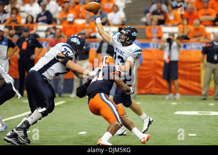 19. September 2010 - Syracuse, New York, Vereinigte Staaten von Amerika - Maine Black Bears Quarterback Warren Smith (13) macht den Pass als Teamkollege Maine Black Bears offensive Linienrichter Alex Batanian (76) macht den Block über Syracuse Orange Sicherheit Shamarko Thomas (21) im vierten Quartal. Syrakus besiegt Maine 38-14 im Hause Opener für die Orange im Carrier Dome in Syracuse, New Yo Stockfoto