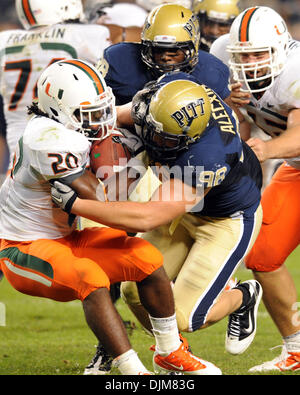 23. September 2010 - Pittsburgh, Pennsylvania, Vereinigte Staaten von Amerika - 23. September 2010: Pittsburgh Panther DL Chas Alecxih (#98) stoppt Miami RB Damien Berry (#20) für einen kurzen Gewinn bei Heinz Field in Pittsburgh, Pennsylvania. Miami schlägt Pittsburgh 31-3. (Kredit-Bild: © Paul Lindenfelser/Southcreek Global/ZUMApress.com) Stockfoto